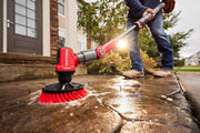 Photo of Craftsman power scrubber CMCPSMB cleaning a wet concrete walkway, red brush attachment in use outdoors.